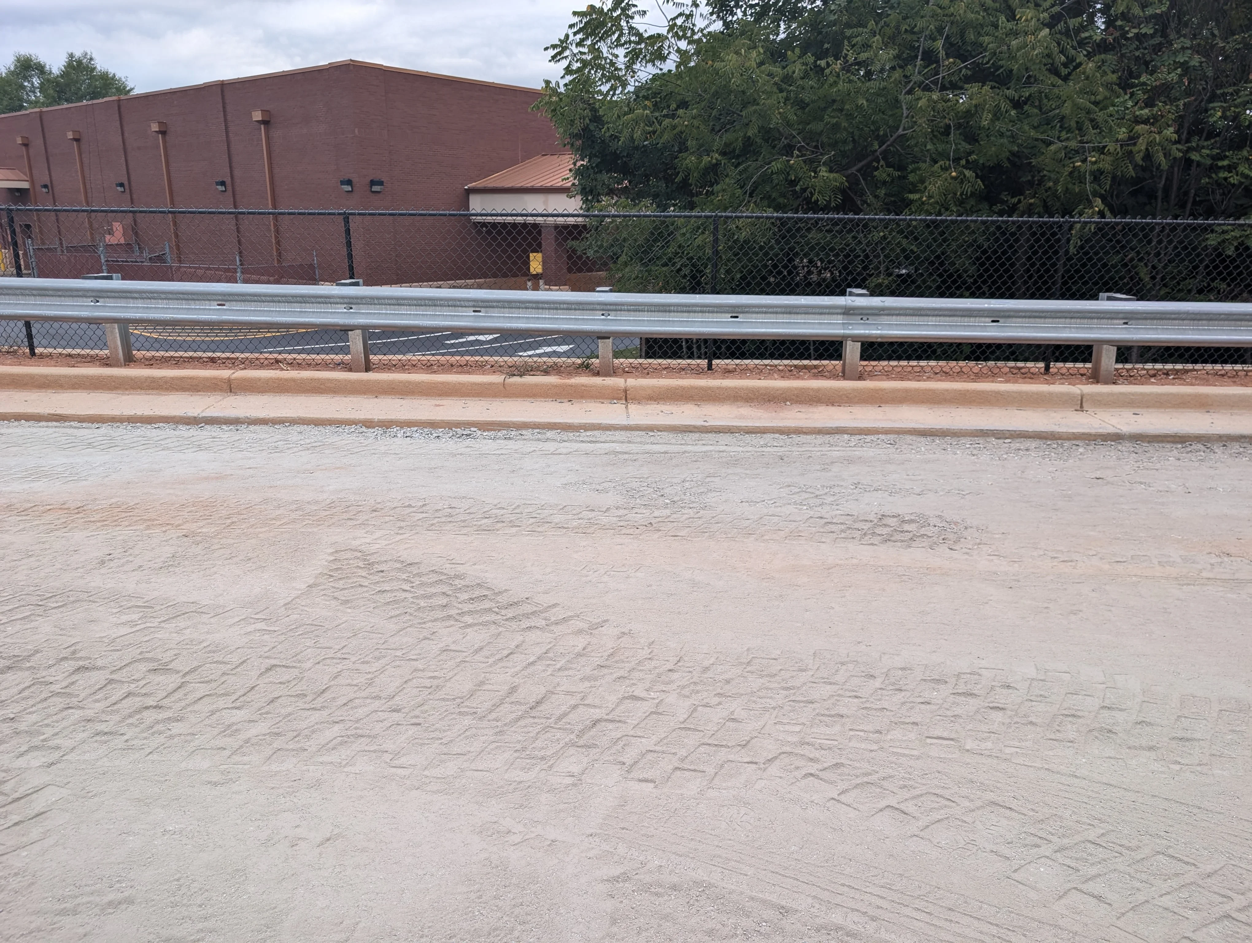 Graded baseball infield with chain-link fencing and metal guardrails installed