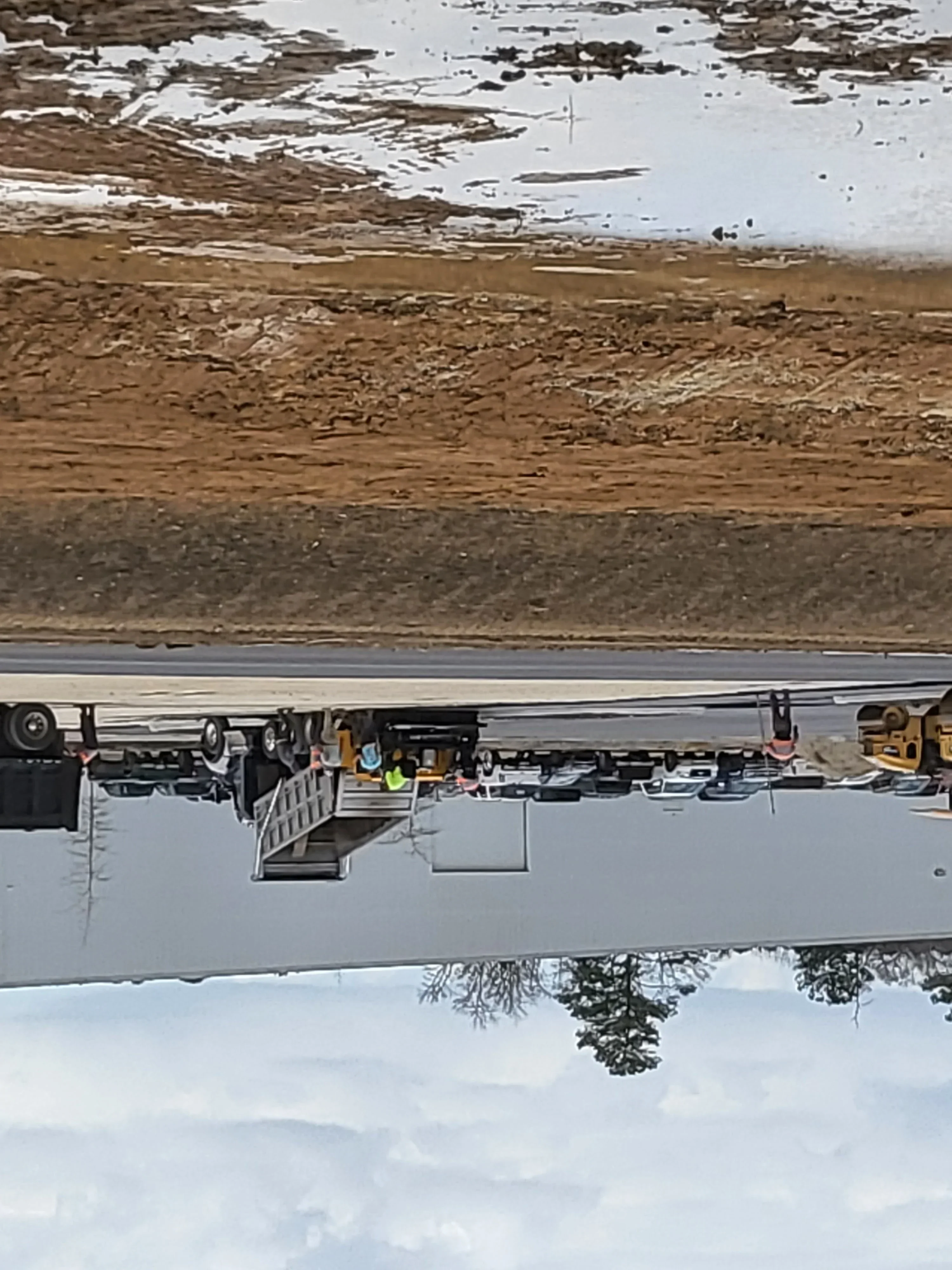 Excavator and dump truck on cleared dirt driveway site with graded soil base