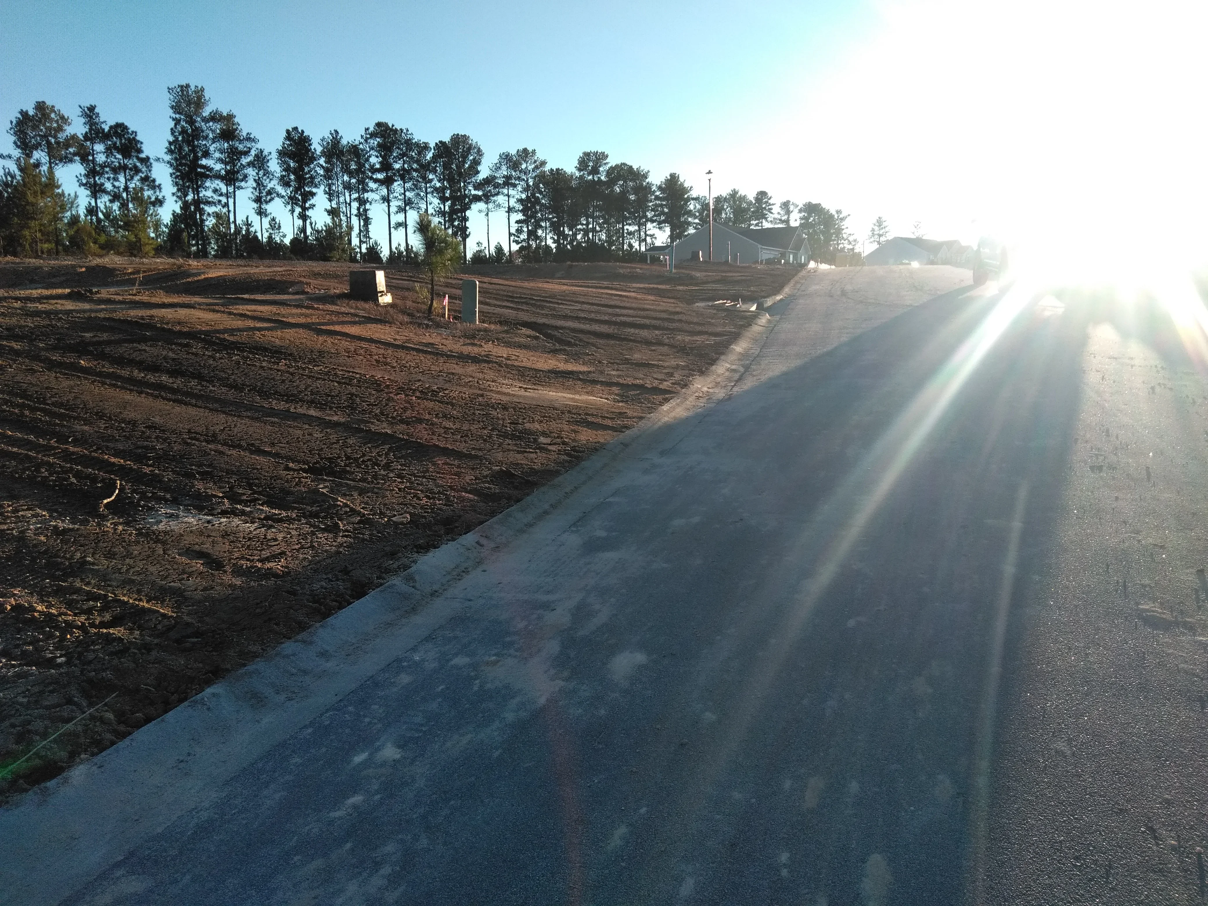 Graded driveway with concrete curb edge and compacted soil base preparation