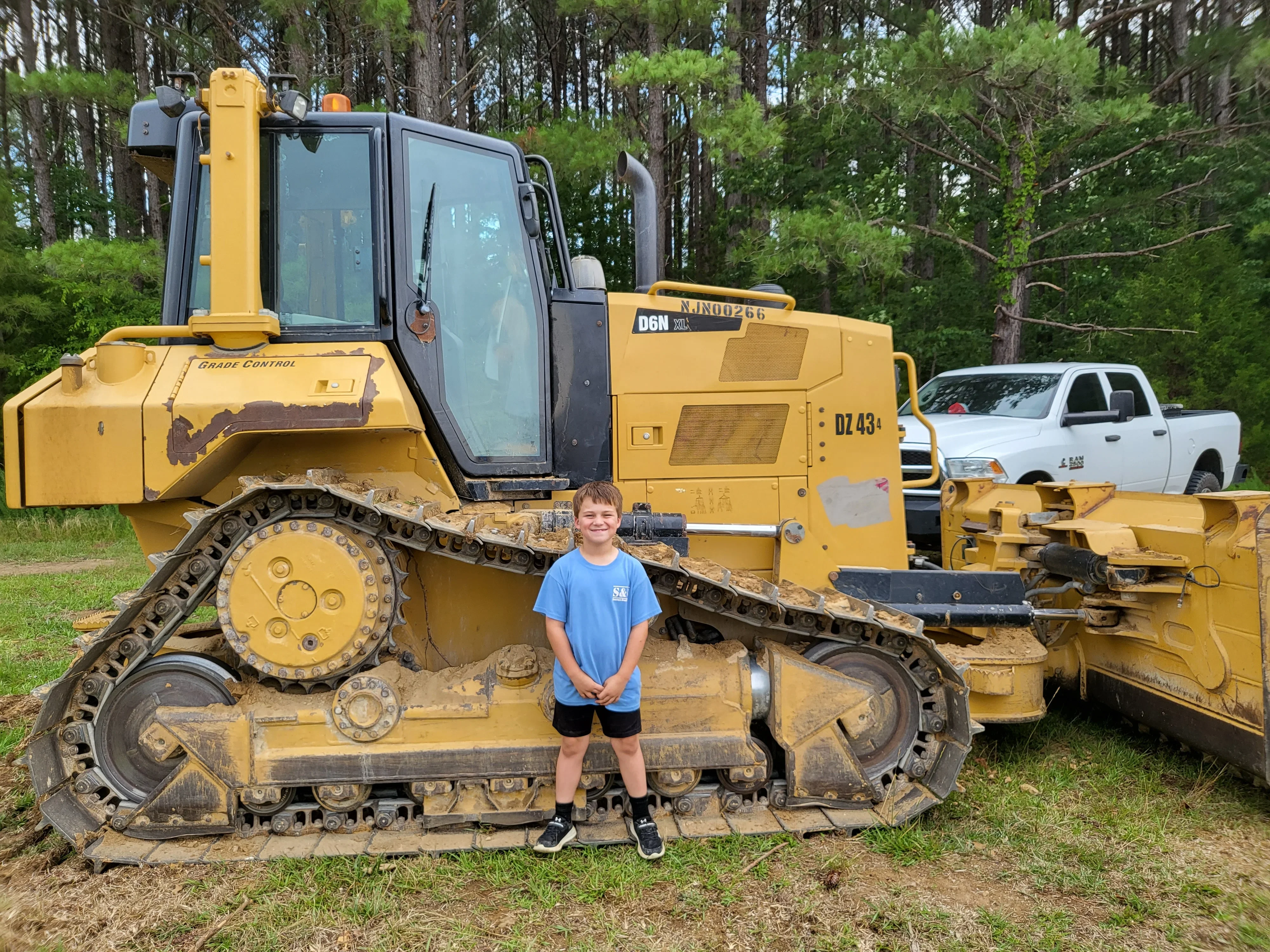 Yellow tracked dozer with Grade Control system and attached grading blade, heavy equipment fleet