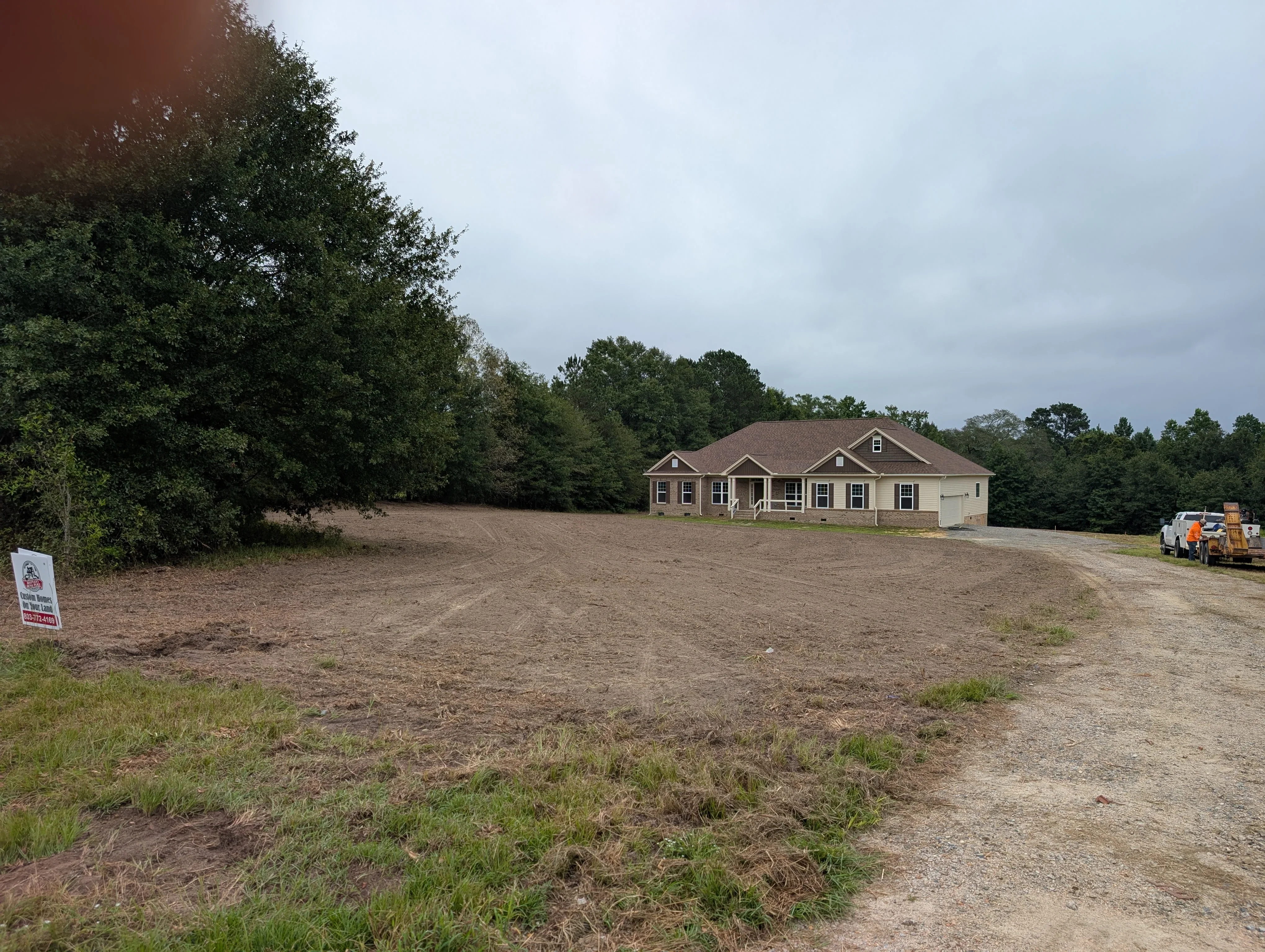 Cleared and graded residential lot with driveway, ready for home construction
