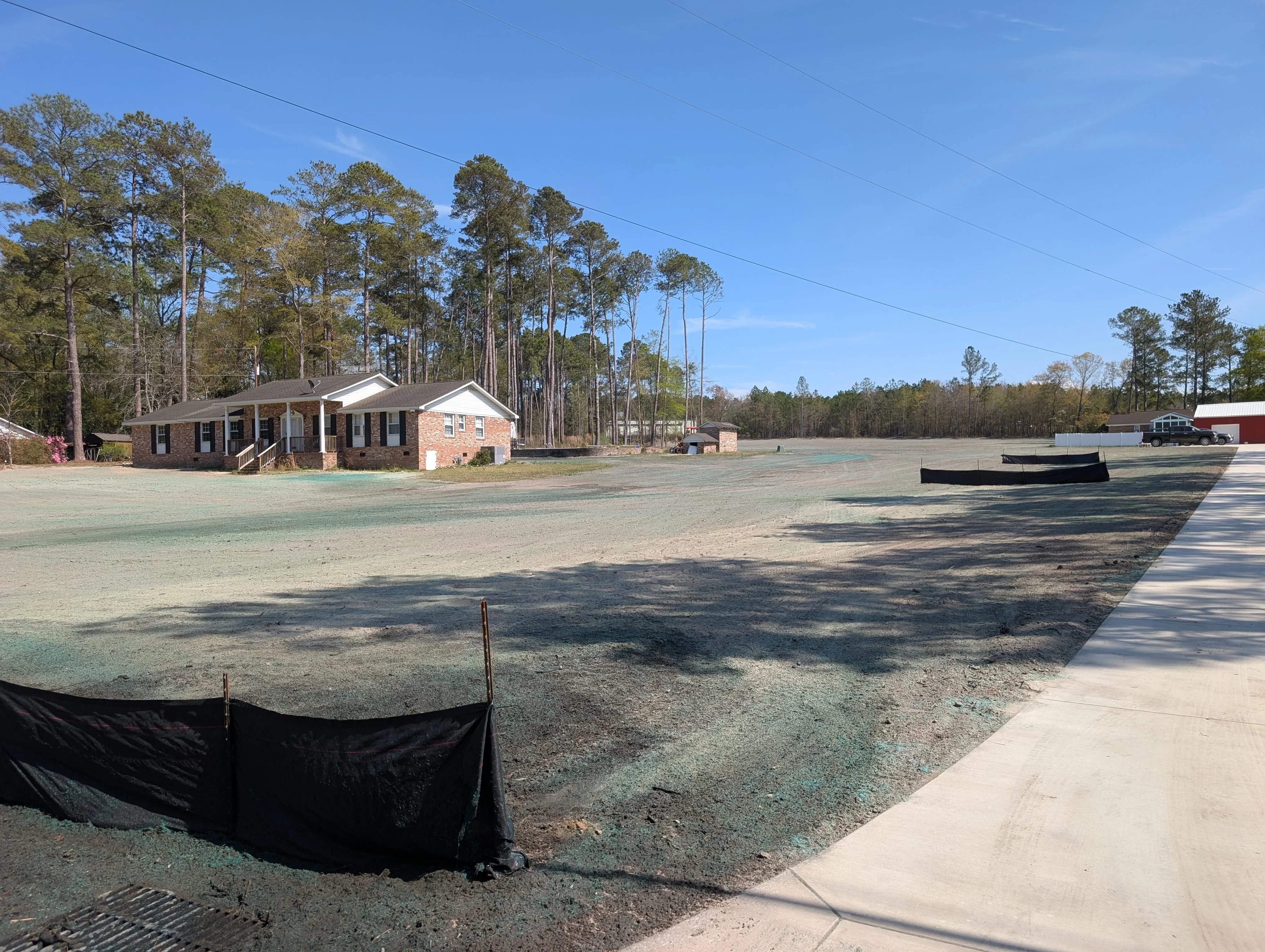 Excavated and graded commercial lot with erosion control fencing and prepared subgrade