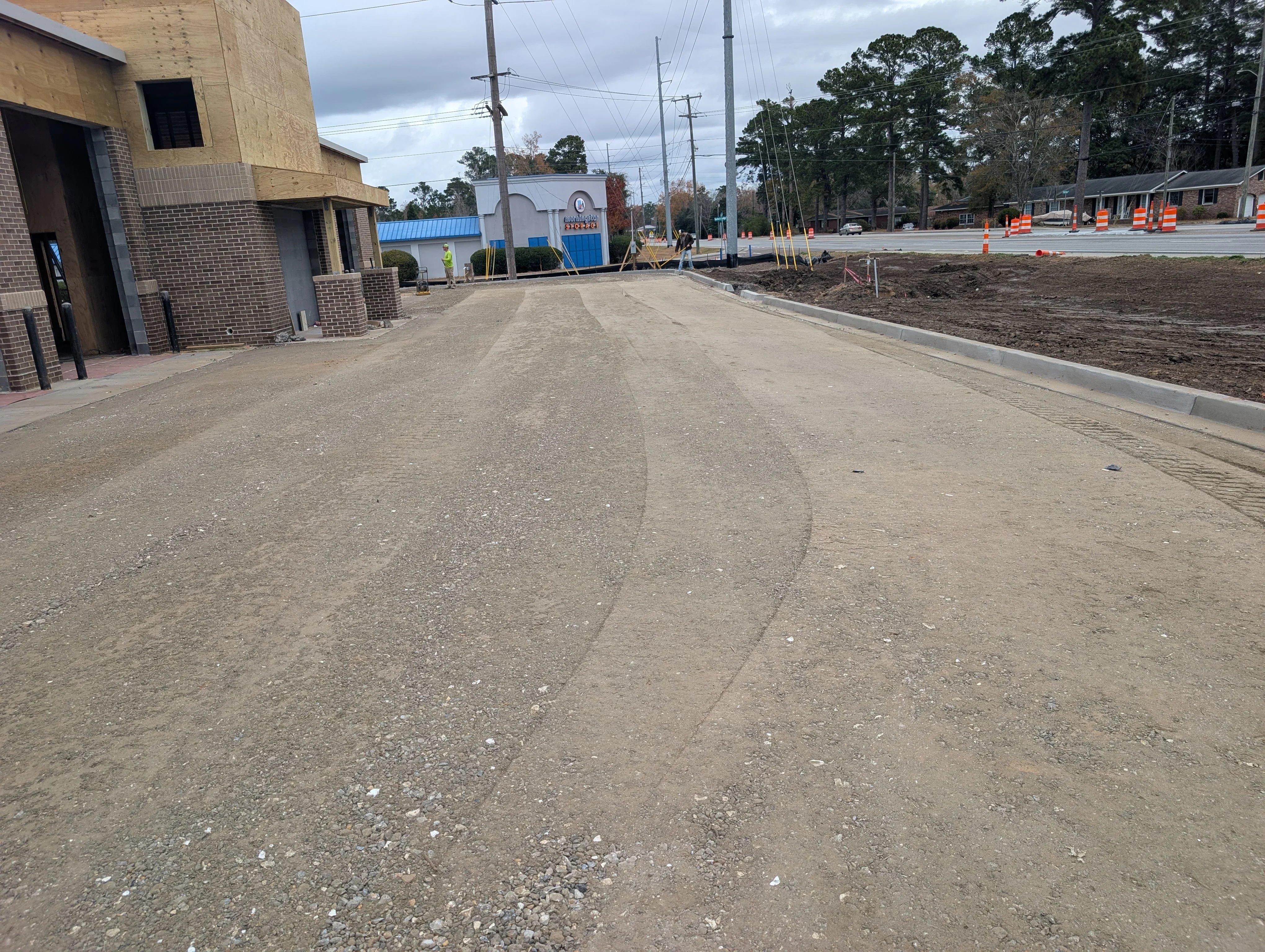 Graded commercial driveway with concrete curbing and compacted base material