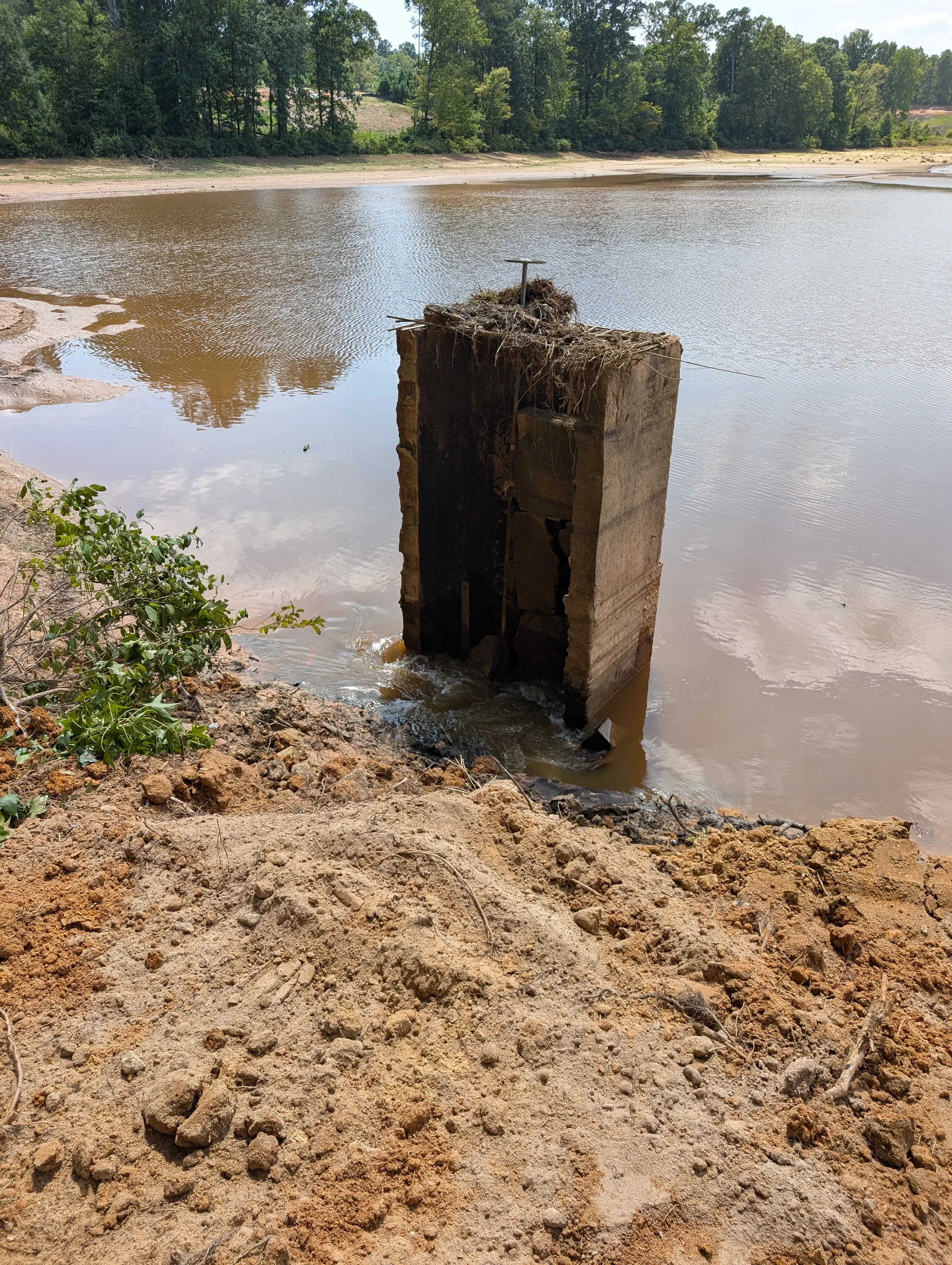Concrete piling removal from riverbank with excavated soil and debris cleared